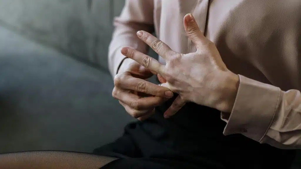 A person removing a ring from their finger.