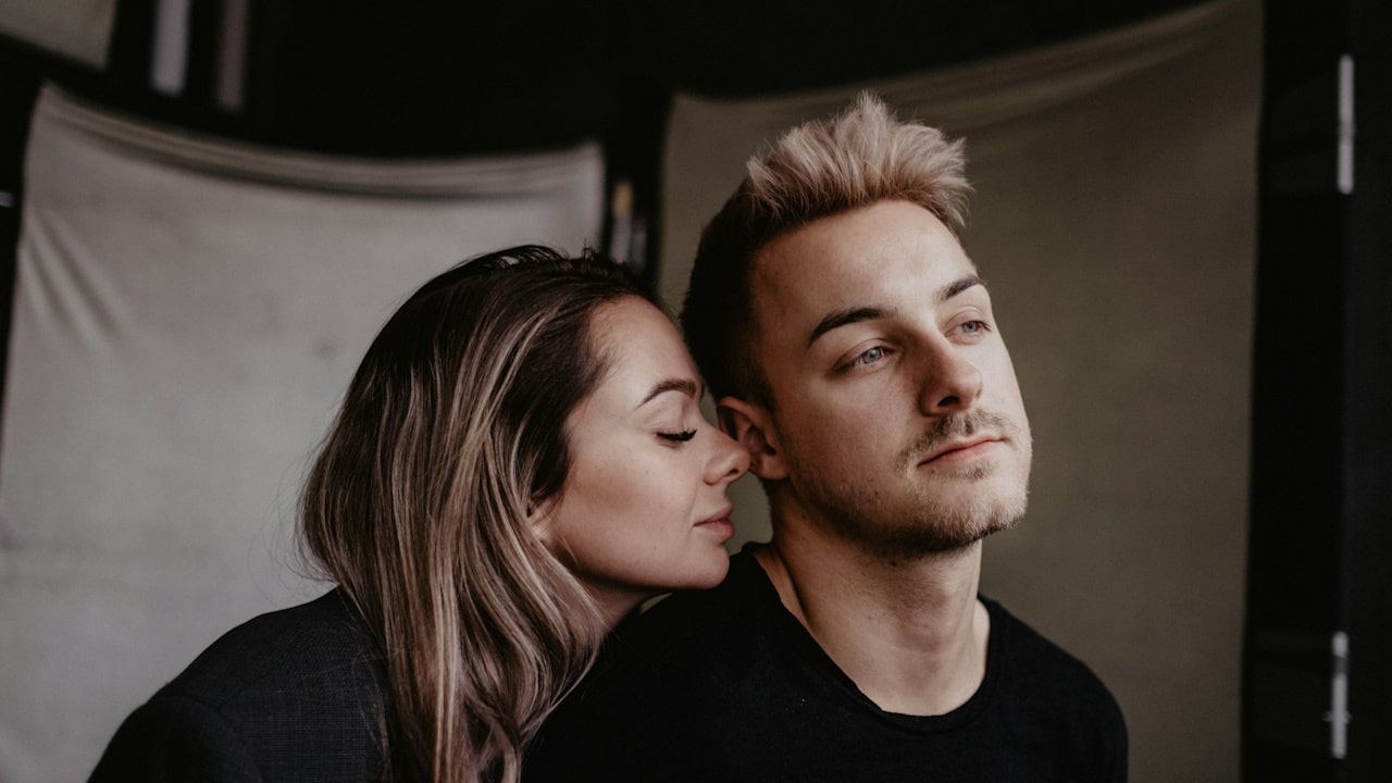 A woman about to kiss a man’s cheek.