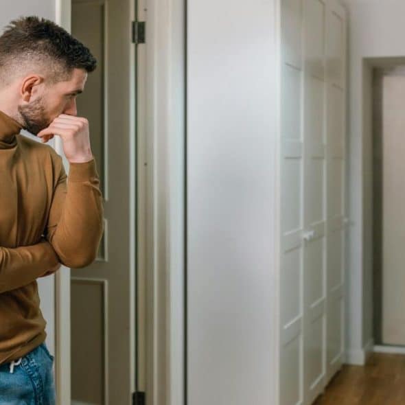 A man looking at a woman walking out of the apartment
