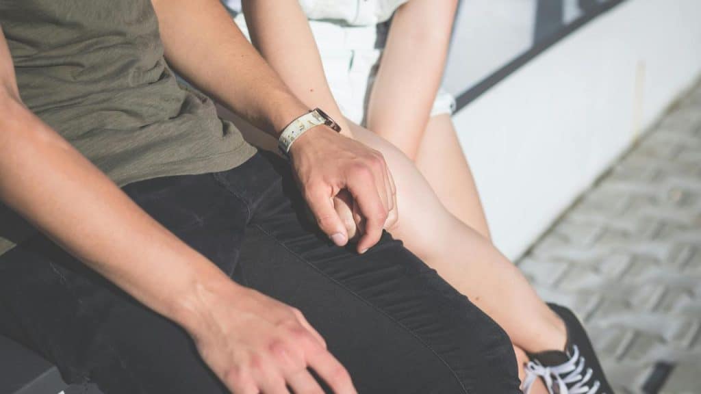 A couple sitting close together on a bench.