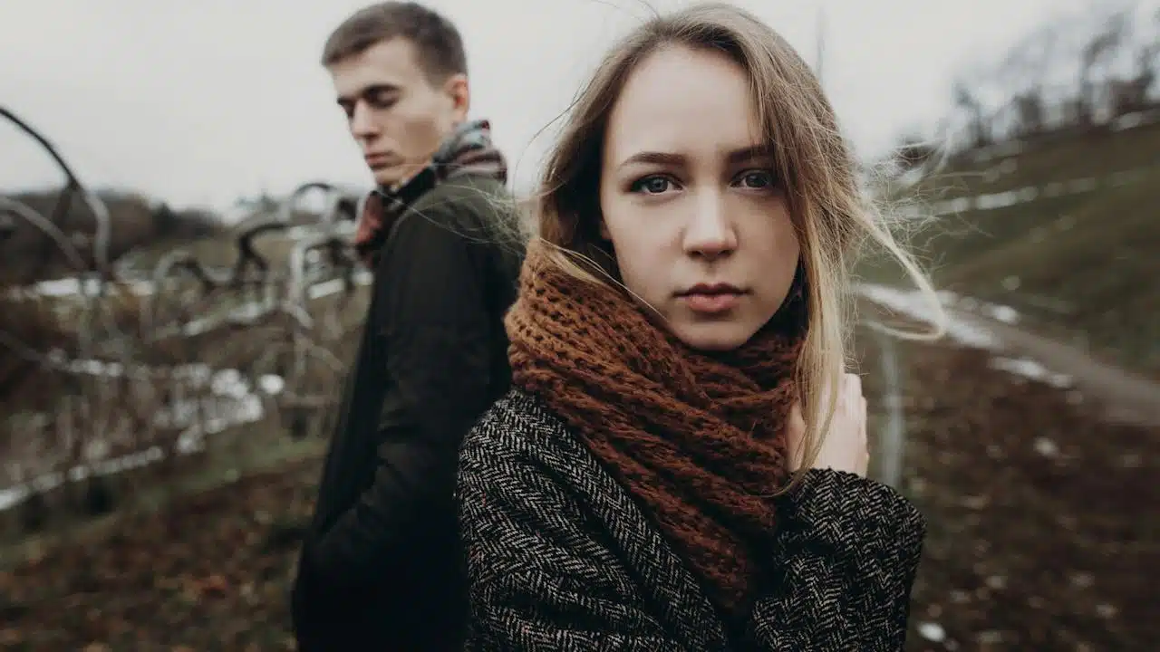 A sad couple standing outdoors.