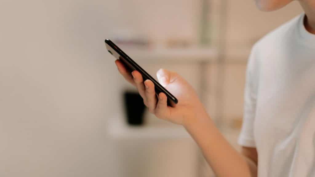 A person holding and looking at a smartphone.