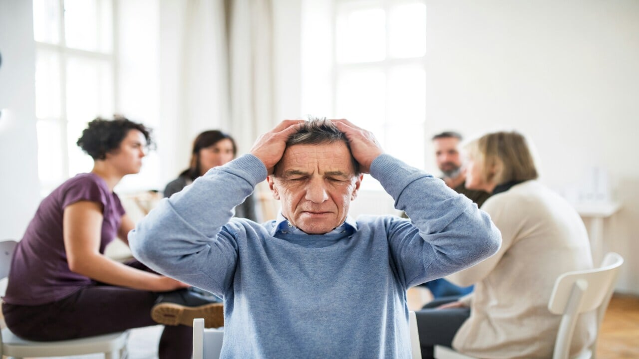 An older man looking frustrated at his family