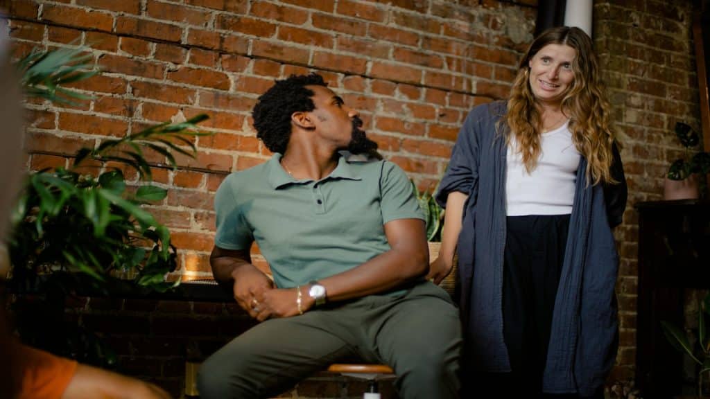 man sitting quietly thinking while partner looks curious
