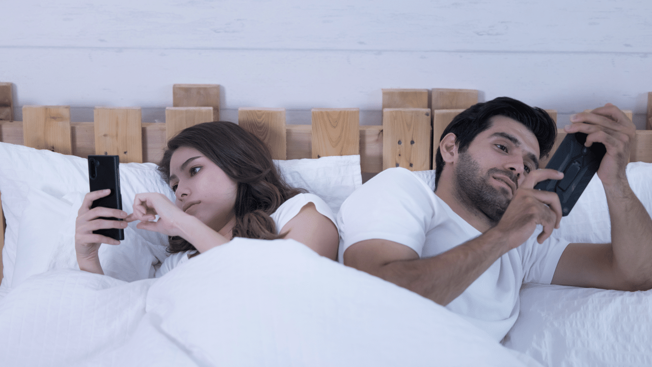 A couple ignoring each other for their phones