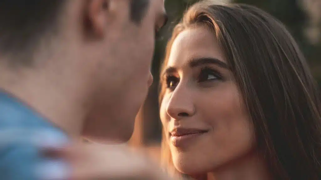 A happy woman with her head tilted, looking up at a man.