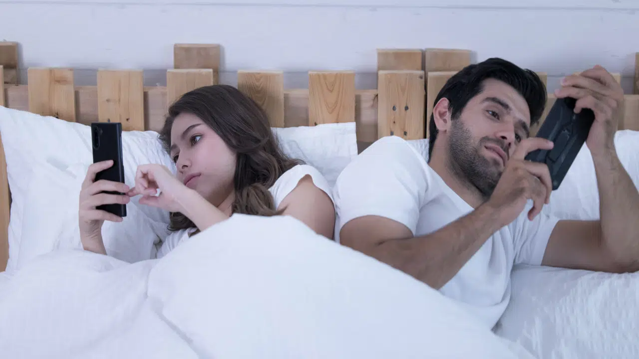 A couple using their phones at home
