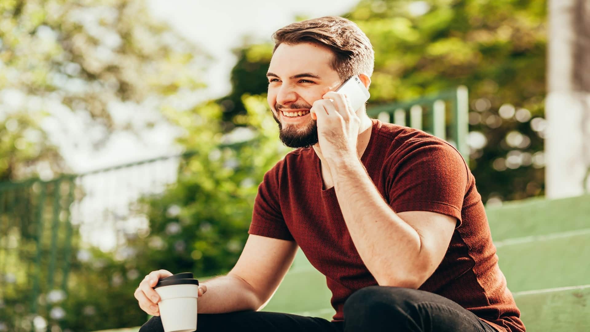 man smiling during conversation outdoors
