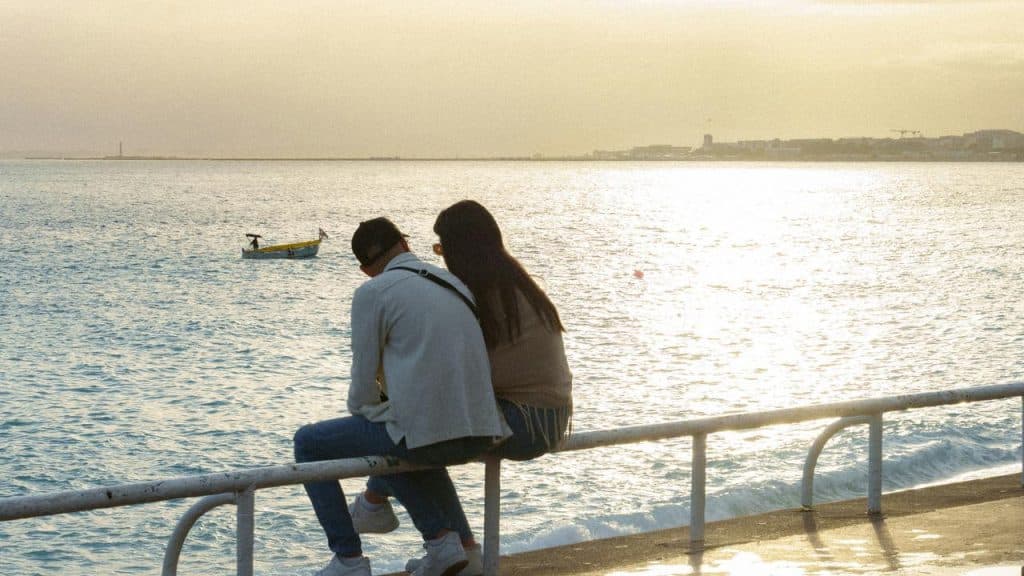 A couple sitting on a railing