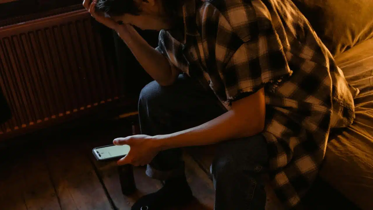 A person sitting and looking at a phone