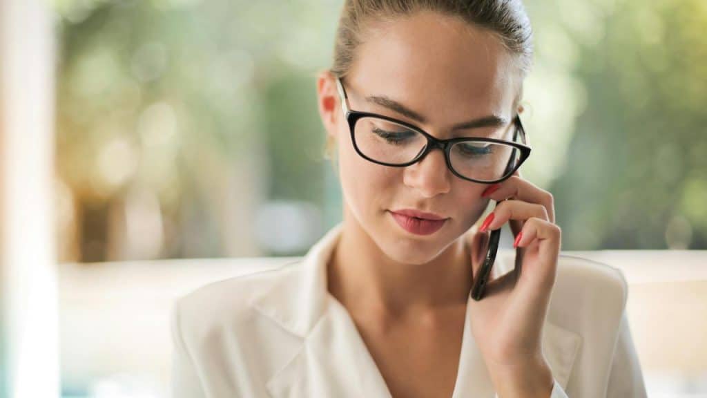 A woman wearing glasses talking on her phone