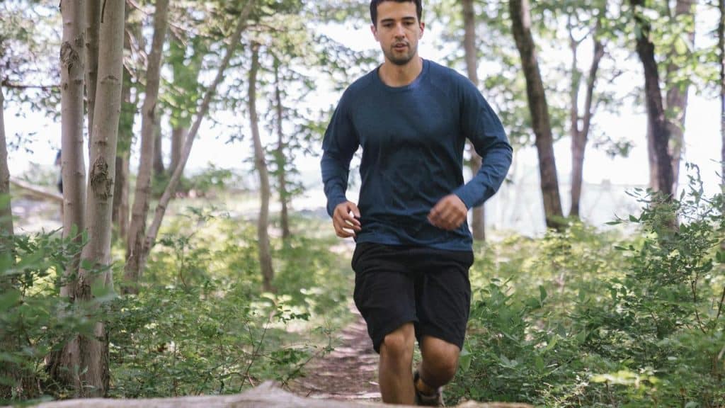 A man jogging along a forest trail.