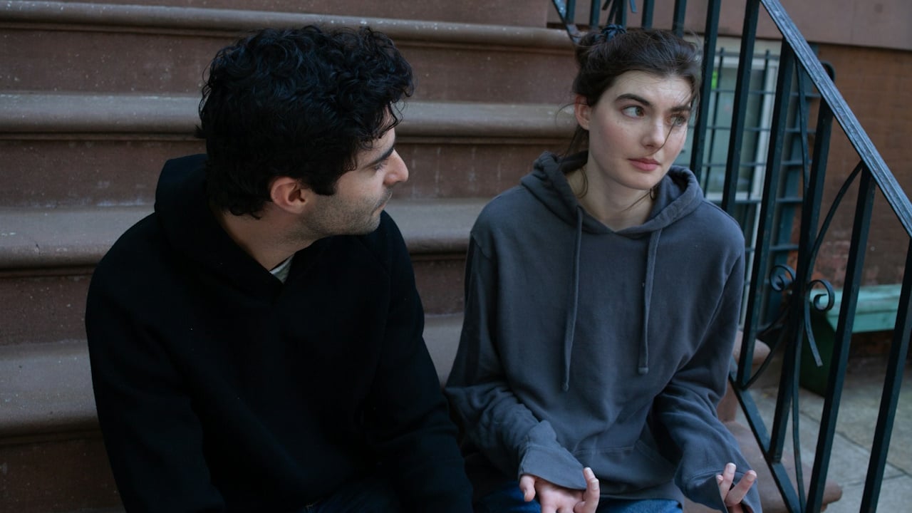 A couple talking while sitting on the stairs.