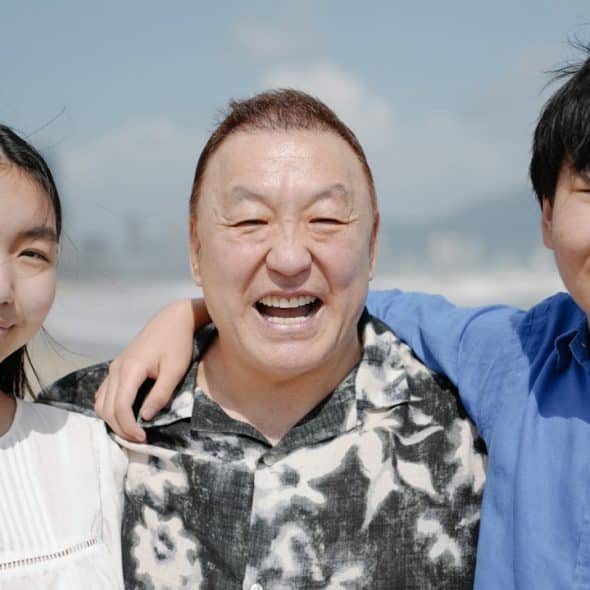 A man and two children on a beach.