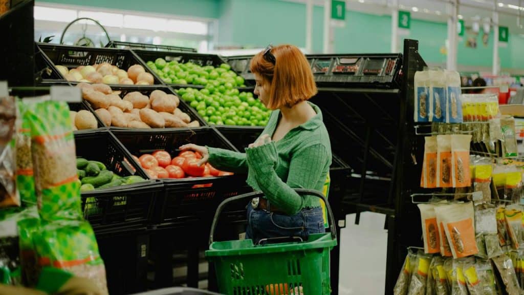 A woman is shopping for vegetables at the grocery store.