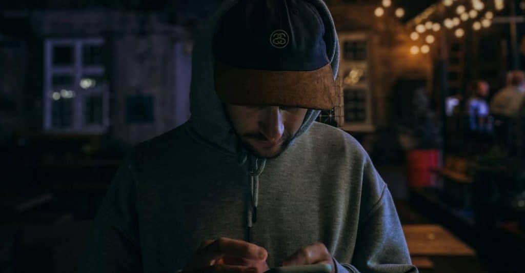man scrolling phone night