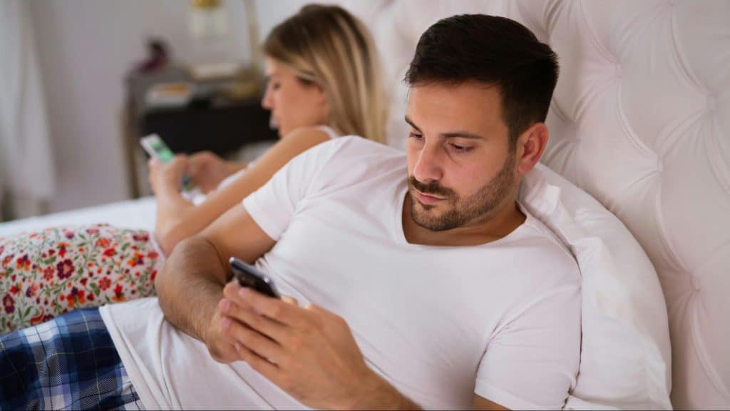 A man texting someone while with his girlfriend