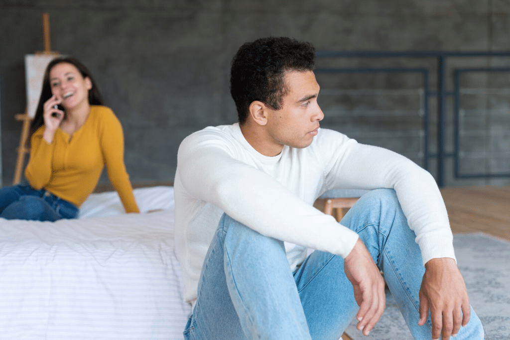 An upset man and a woman busy with her phone