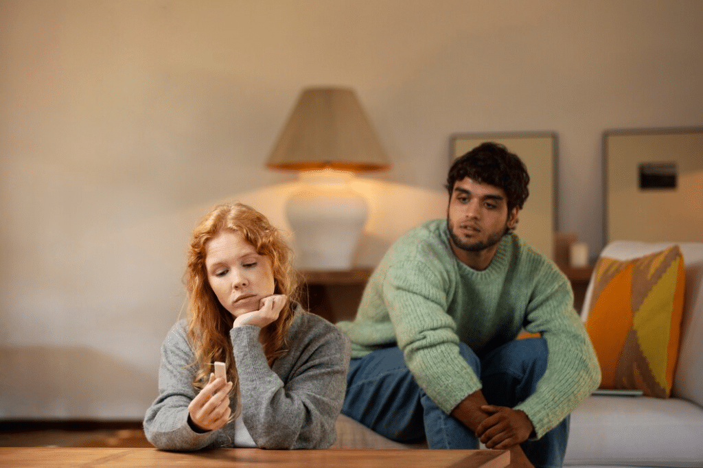 Couple at home in living room not talking to each other