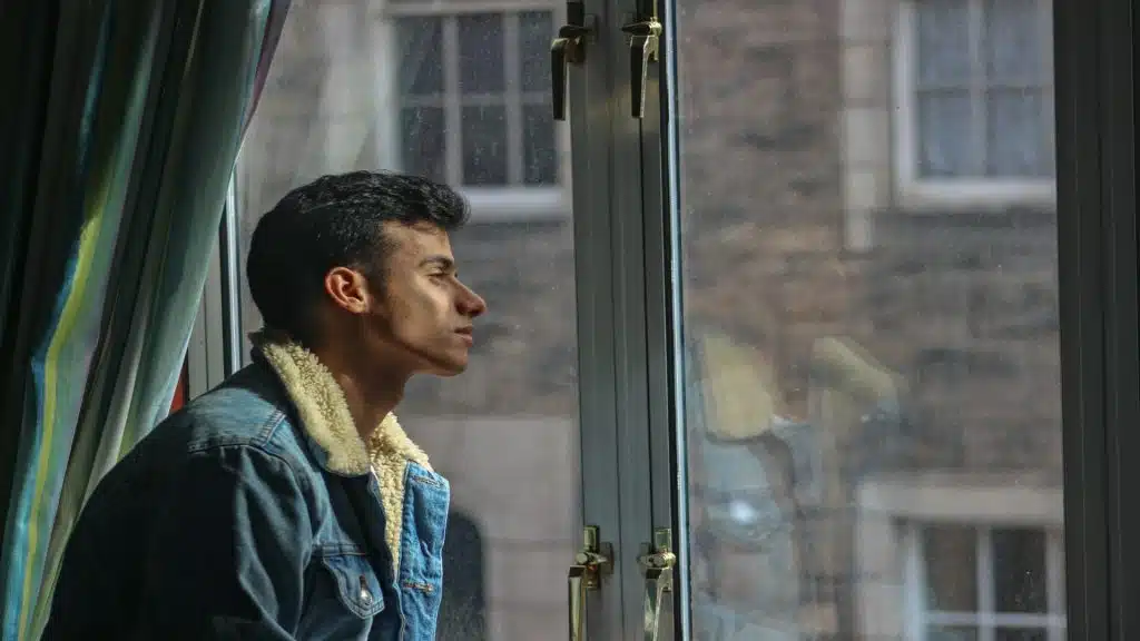 man sitting thoughtfully by window