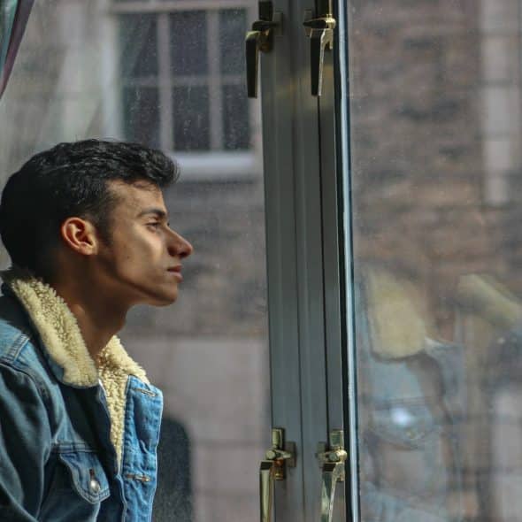man sitting thoughtfully by window