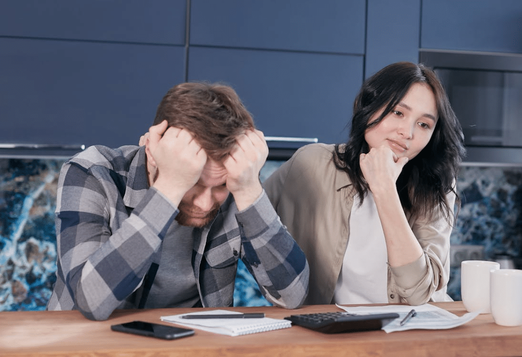 Stressed couple on desk with overloaded notes