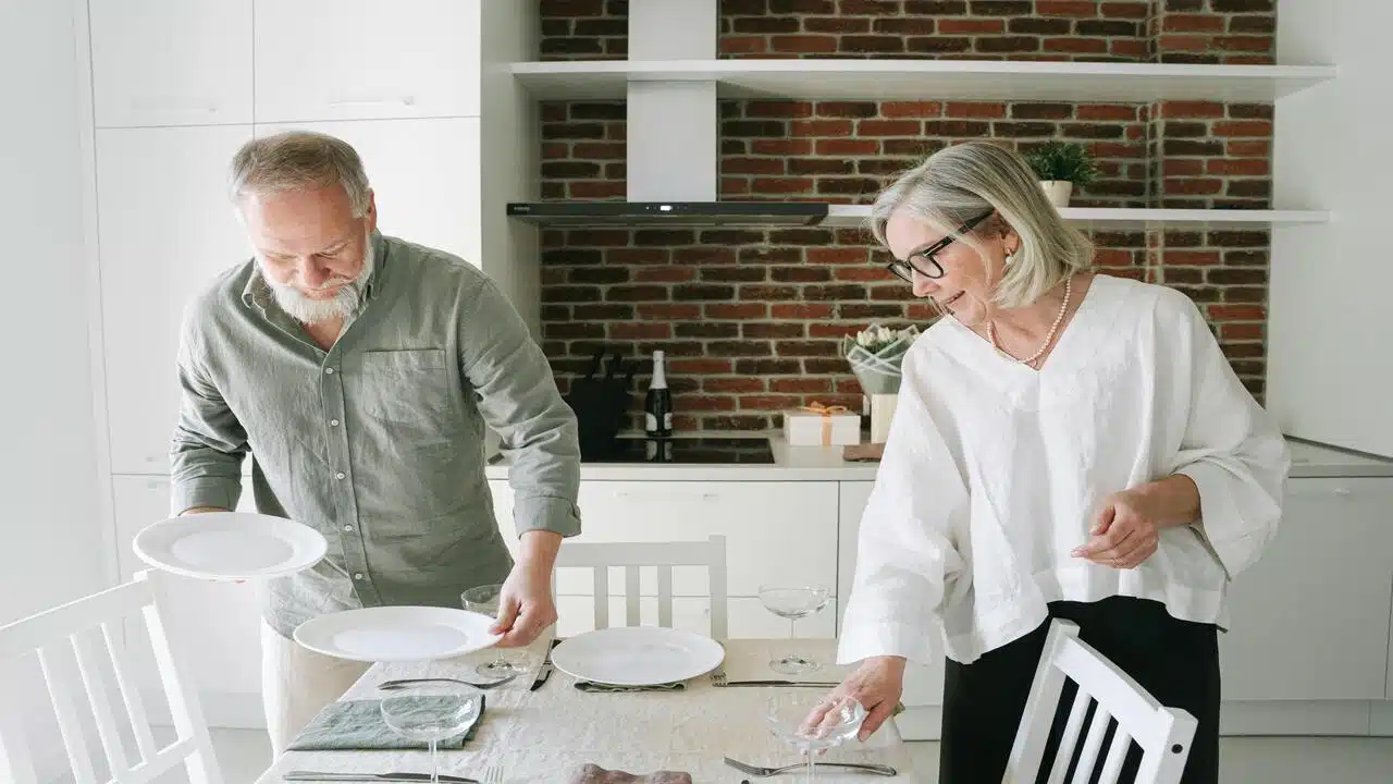 A mature couple setting the table