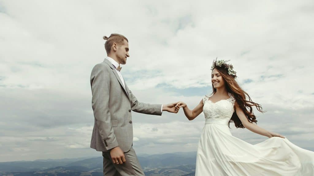 A couple posing for a picture in a hilly area.