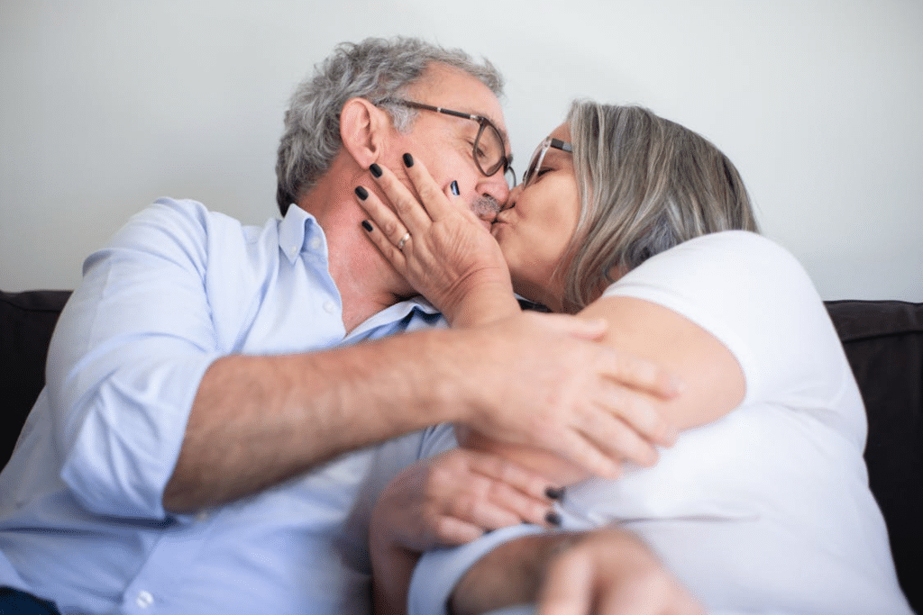 An Elderly Couple Kissing on Couch