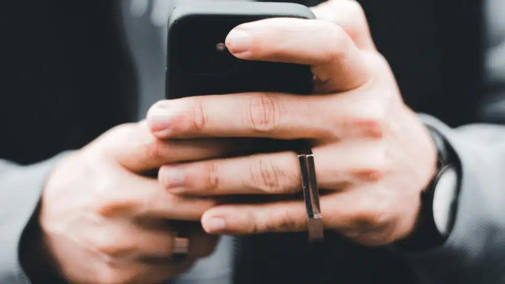 A person holding and using a smartphone with both hands.