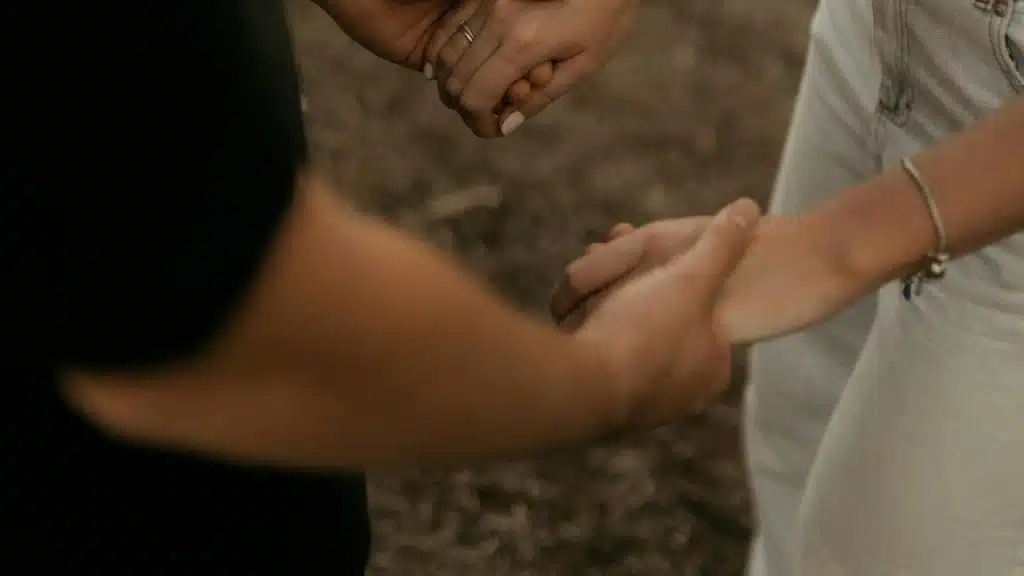 A couple holding hands outdoors.