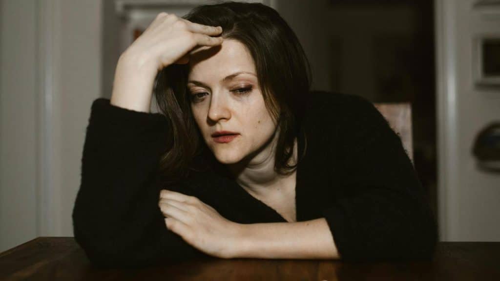 A worried woman resting her head on her hand