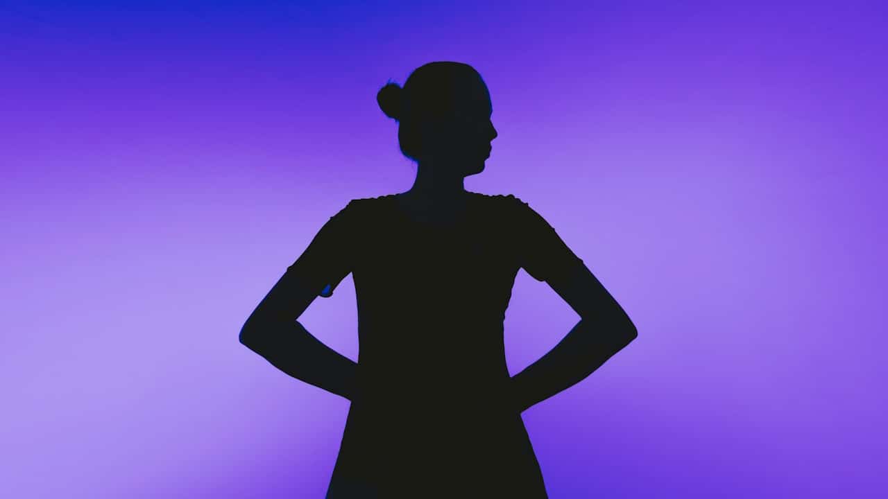 Silhouette of a woman with hands on hips.