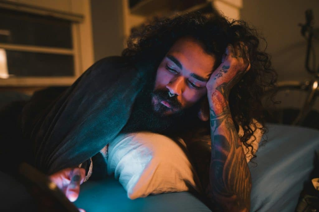 man using phone in bed