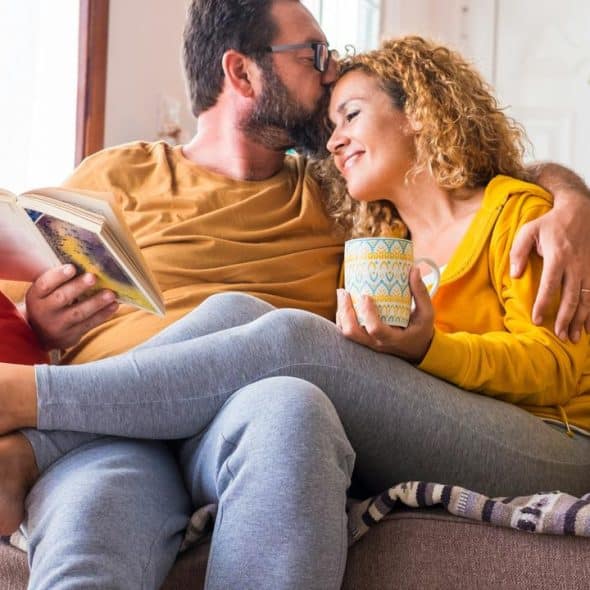 A couple cuddling on a couch
