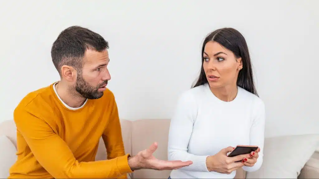 A woman trying to hide her phone from a man