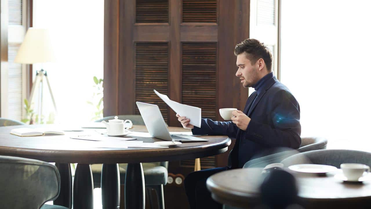 A man sitting at a table, reviewing papers