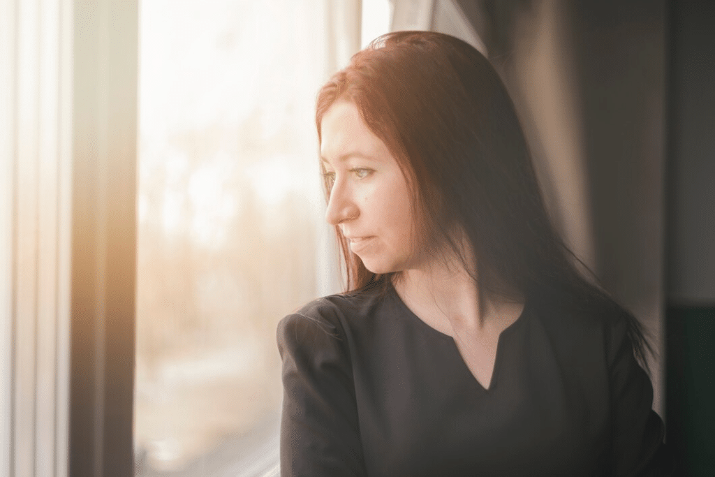 Woman alone bright looking out through window