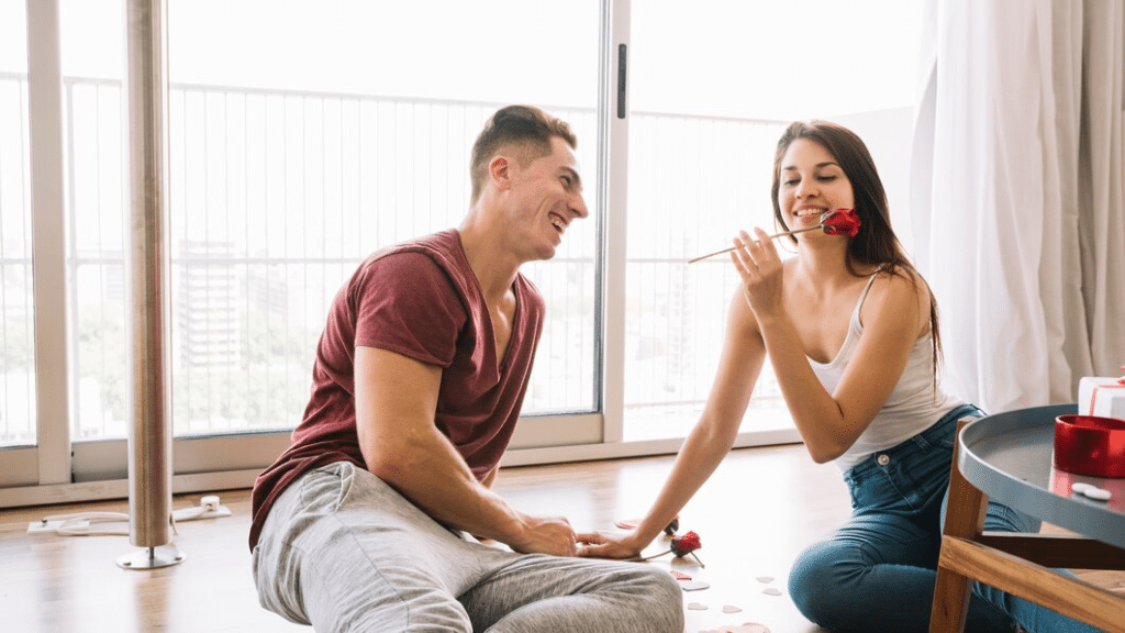 Man and woman sitting with rose on floor