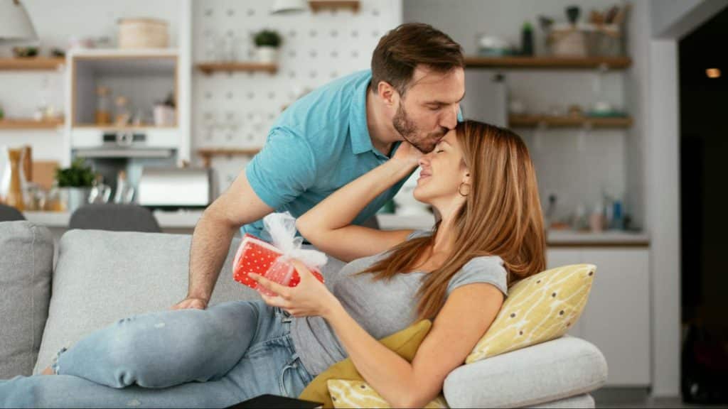 A man kissing woman’s forehead