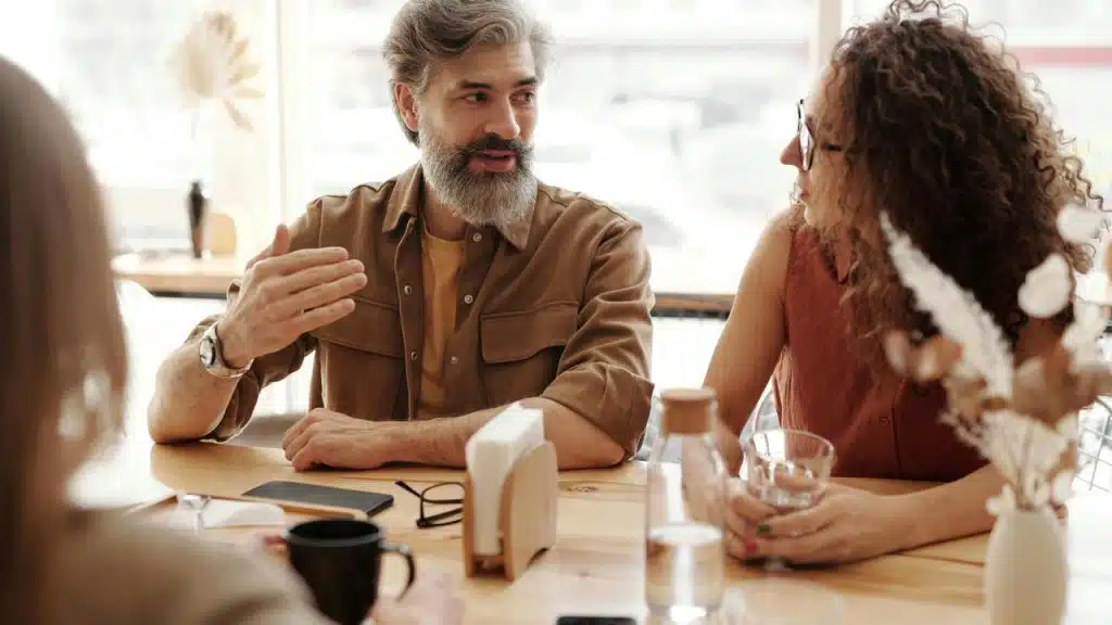 A group of people having a discussion at a café table.