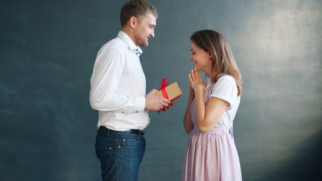 man giving small gift to partner