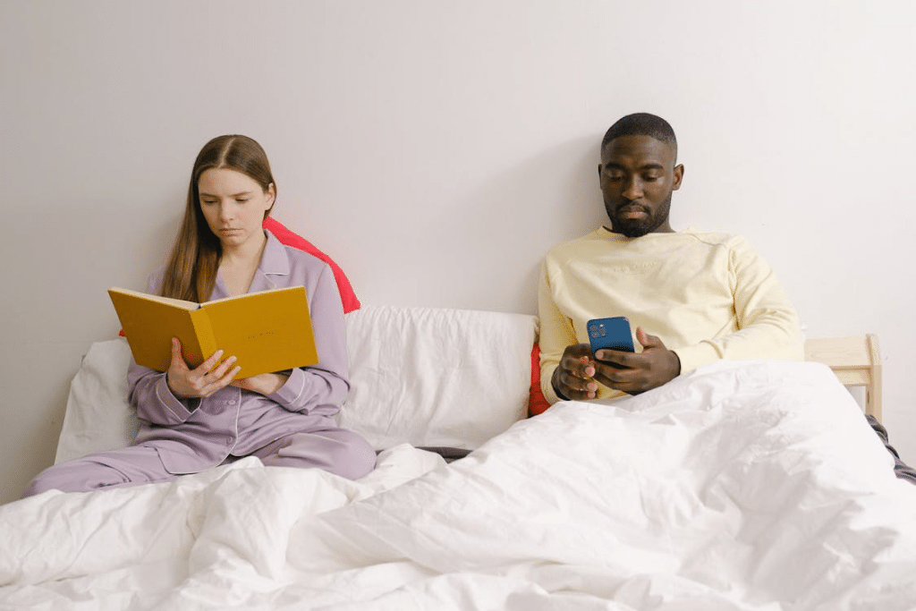 Couple sitting apart on bed