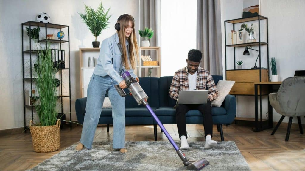 A man busy working and a woman cleaning 