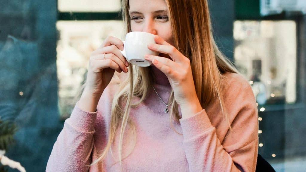 A woman drinking from a cup.