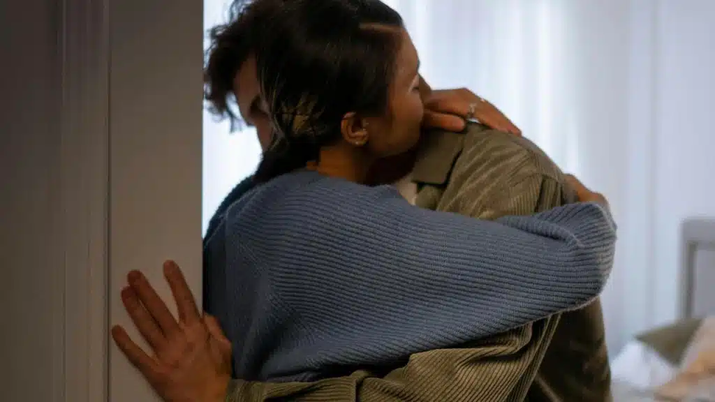 A couple hugging closely indoors.