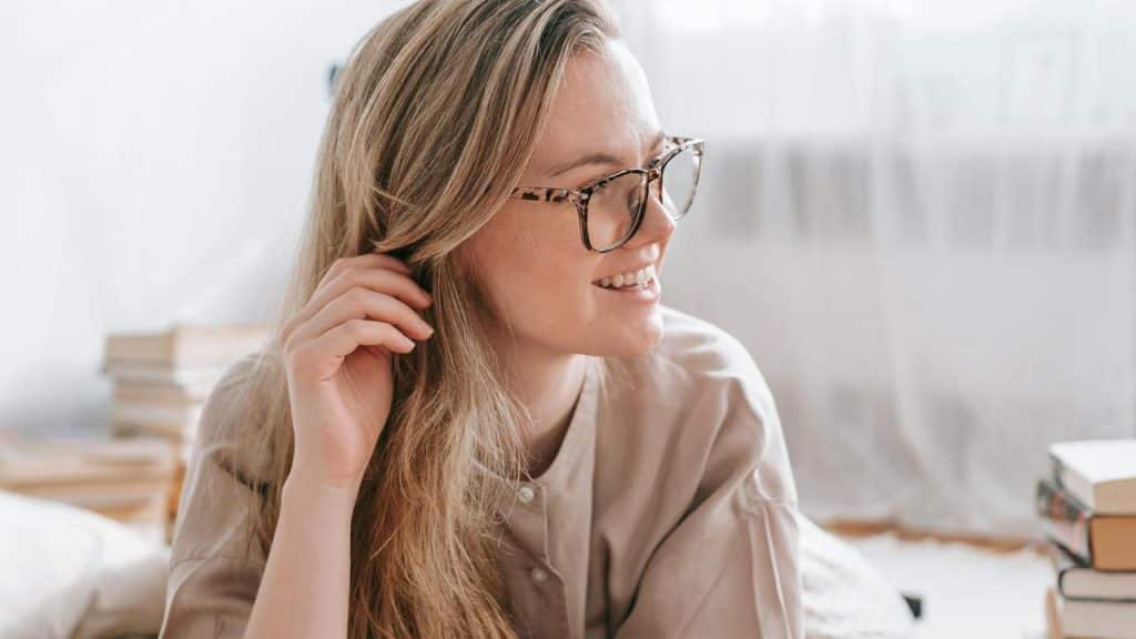A smiling woman wearing glasses indoors.