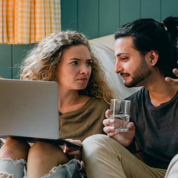A couple talking while looking at a laptop