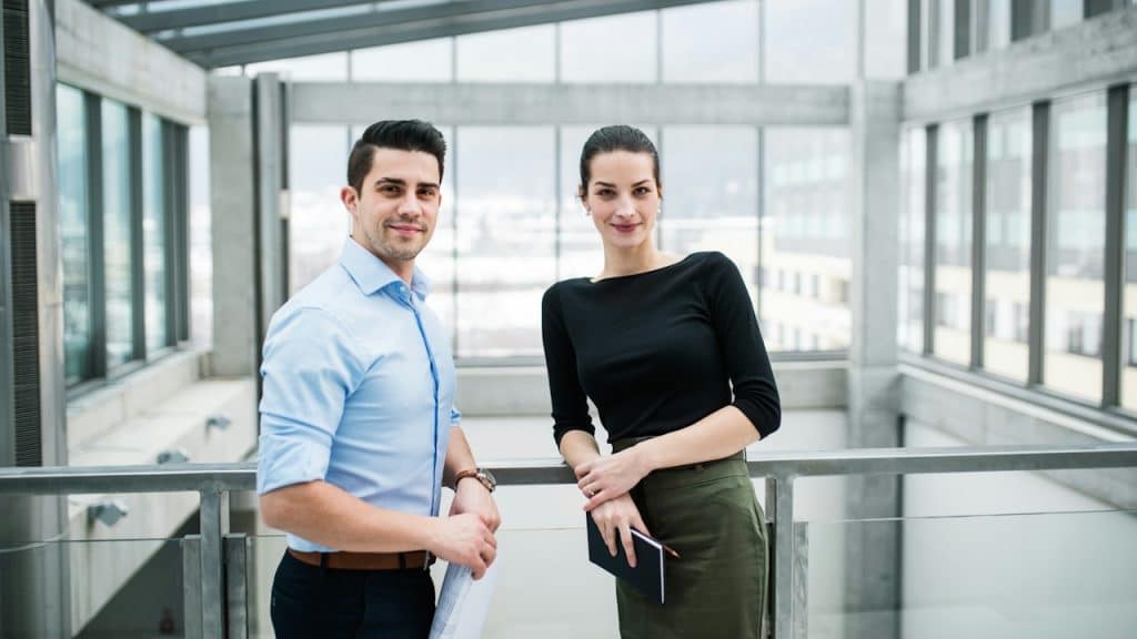 A man and a woman standing in a modern office.
