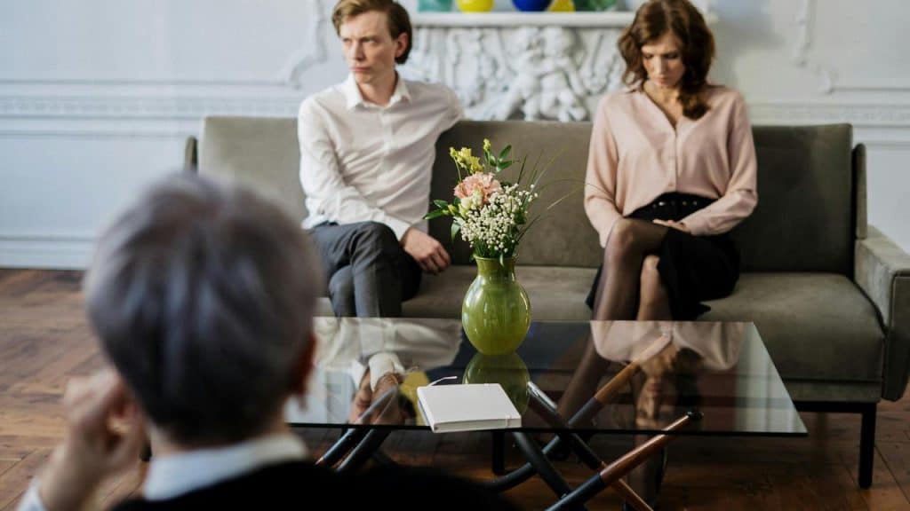 A couple sitting on a couch during a therapy session.
